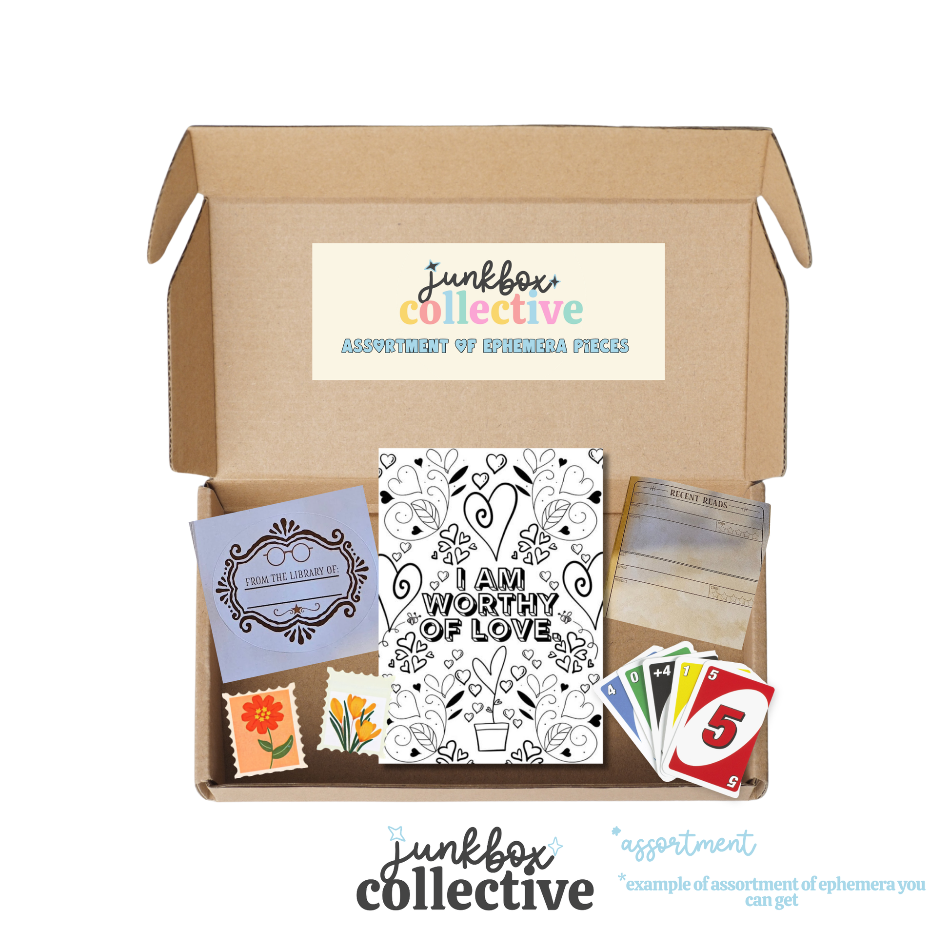 An open cardboard subscription box from Junkbox Collective labeled 'Assortment of Ephemera Pieces' on a white background, showing included items such as a black-and-white 'I Am Worthy of Love' card, a purple decorative card, small flower stamps, a colorful numbered card, and a stack of cards.